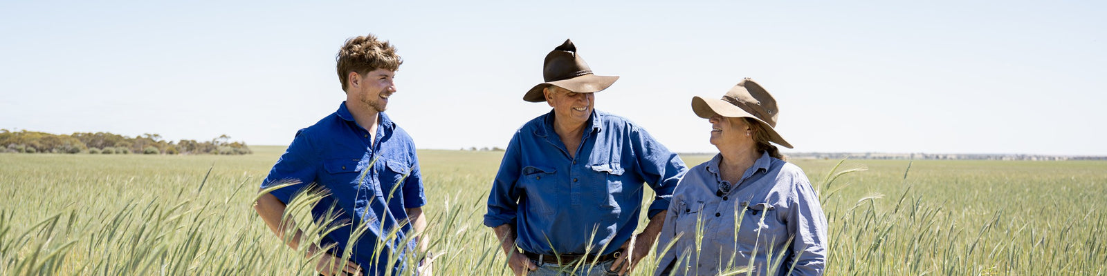 Three generations of the Haggerty family standing together in a green wheat crop on their Western Australian farm