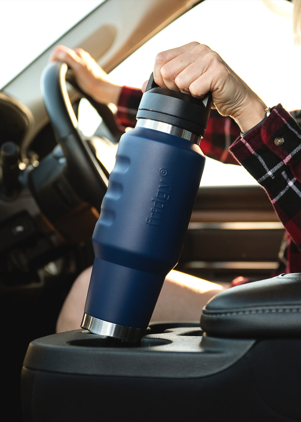 Fridgy 1L Cruise Range Bottle in Navy being taken out of a car cup holder – Double-wall vacuum insulated stainless steel drink bottle designed for travel-friendly hydration.
