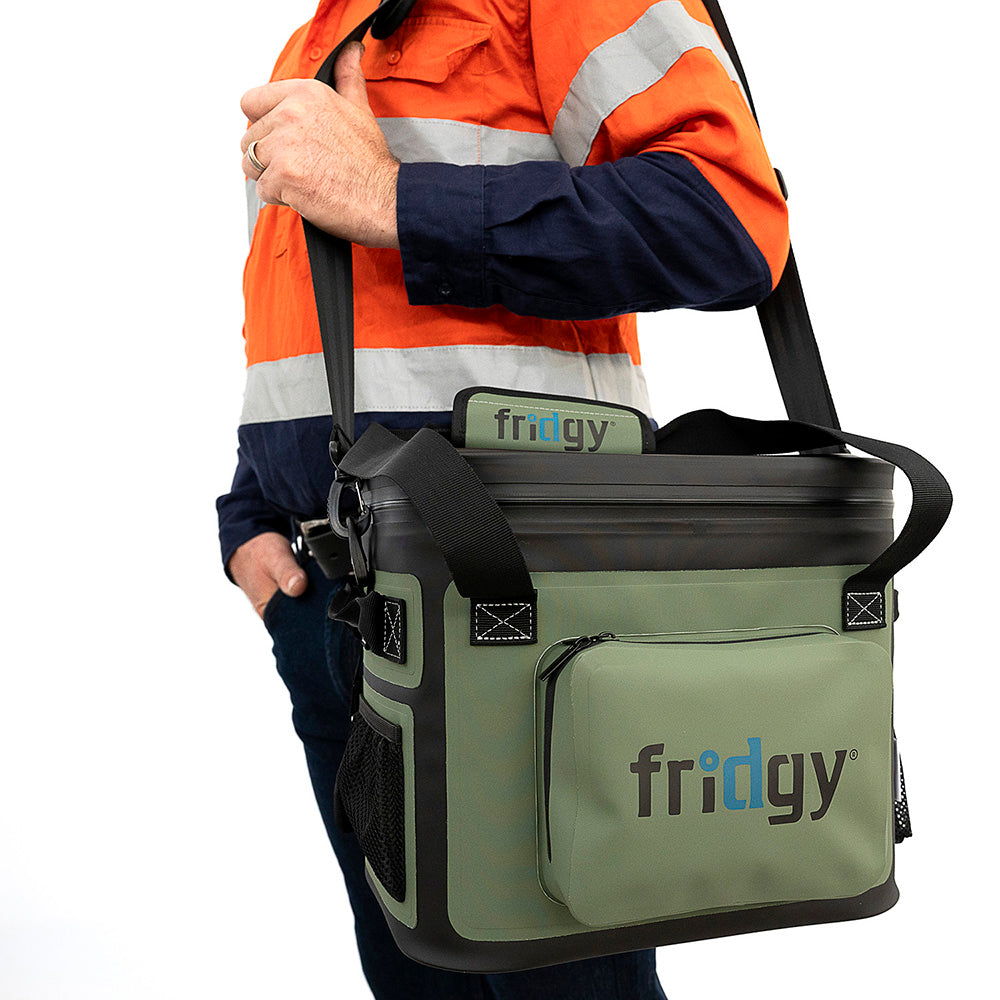 Man in high-vis wearing the shoulder strap of a Fridgy 14L CribMate in Commando Green – Insulated soft cooler designed for durability and keeping food and drinks fresh on the job site.