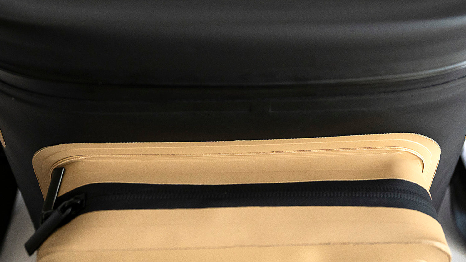 Close-up high-angle view of front pocket on Fridgy 20L CribMate Weekender in Sandy Taupe – Insulated soft cooler showcasing its durable, water-resistant front storage pocket and rugged construction.