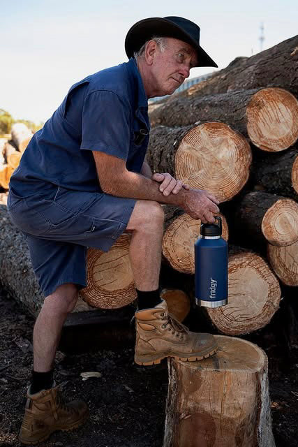 Aussie hard worker holding a Fridgy Grip Range Bottle – Double-wall vacuum insulated stainless steel water bottle designed for durability and all-day hydration on tough job sites.