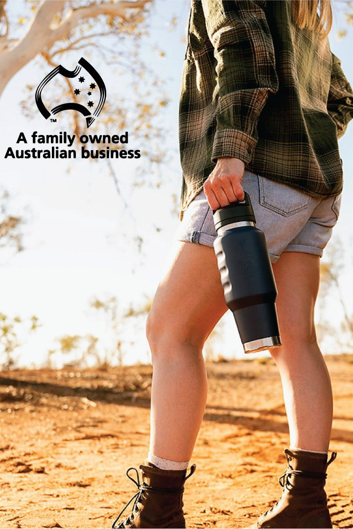 Fridgy 1L Cruise Range Bottle – Double-wall vacuum insulated stainless steel water bottle being held by an Aussie woman in the outback, designed for durable, travel-friendly hydration.