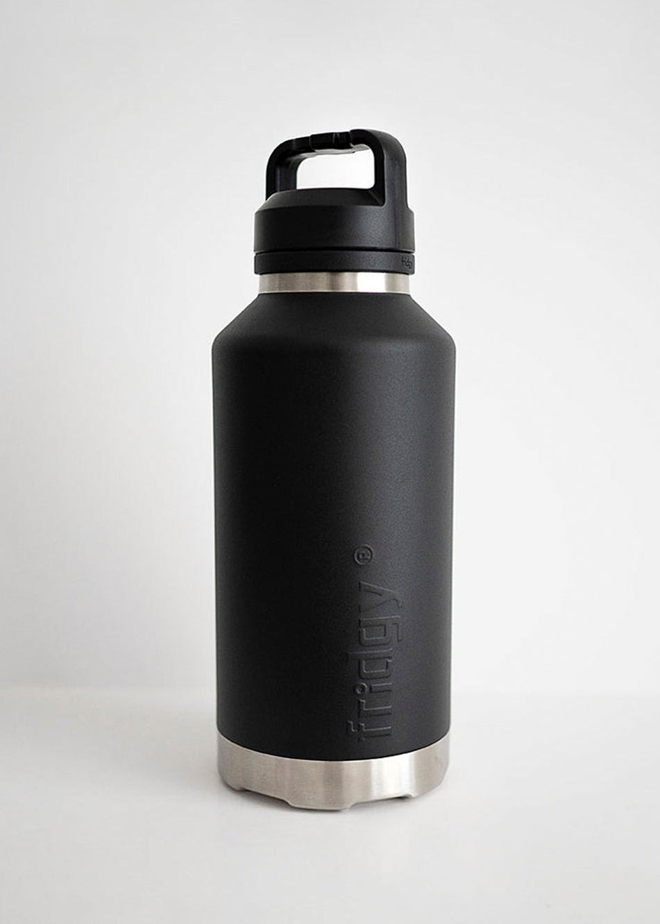 Fridgy All-Dayer Bottle in Black placed in front of a man using a chainsaw – Triple-wall insulated stainless steel water bottle designed for all-day hydration in rugged conditions.
