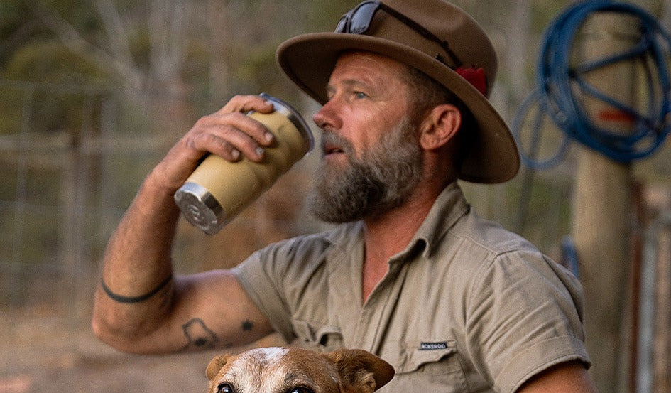 A station worker in a wide-brim hat drinking from a taupe Fridgy 600ml tumbler.